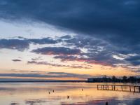 Erstes Glühen an den Wolkenunterseiten über dem Chiemsee